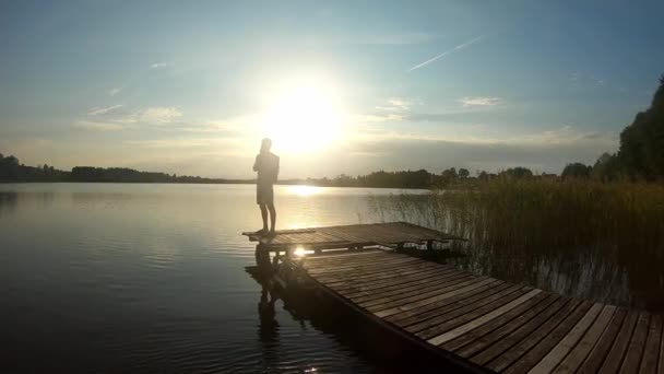 Aerial Orbital Shot Teenager Standing Bridge Calm Lake Looking Horizon — Stok video