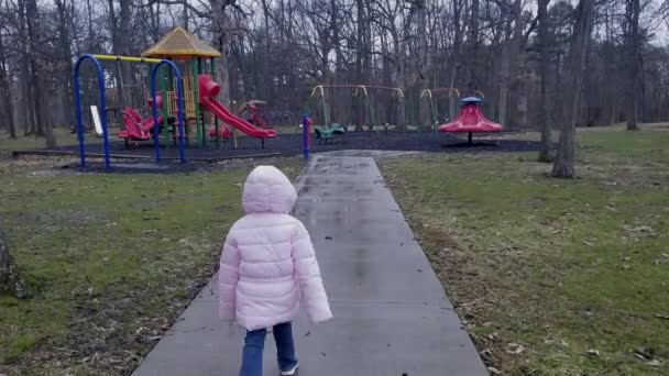 Young Girl Walks Away Camera Playground Background Concrete Sidewalk Rain — Video Stock