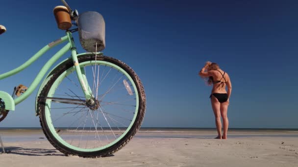 Wide Shot Bike Foreground Standing Woman Sits Sand Beach — Wideo stockowe