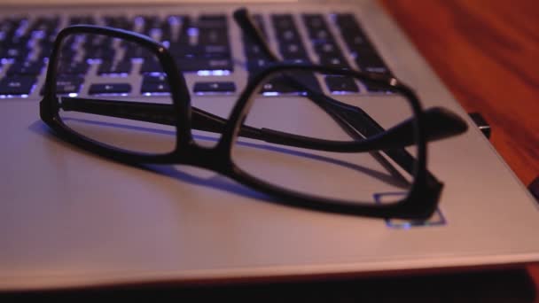 Rack Focus Shot Pair Eyeglasses Resting Top Laptop Computer — 图库视频影像