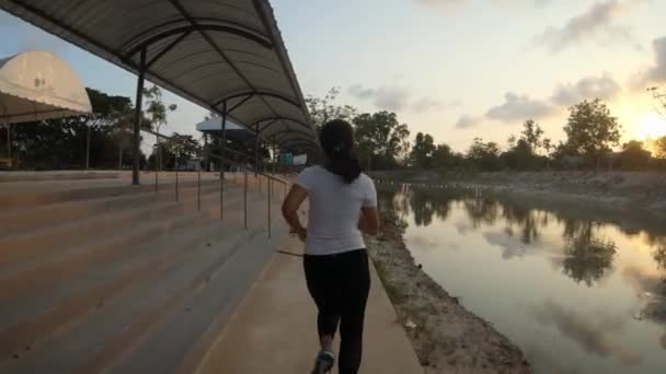 Slowmotion Shot Young Thai Girl Jogging Pavement Small Lake Sunset — Stockvideo