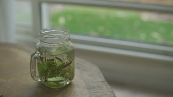 Hand Grabs Glass Mug Herbal Tea Sitting Table — Stockvideo