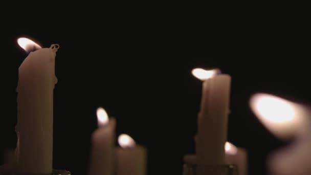 Extreme Close Pan White Candles Lit Black Background — Video Stock