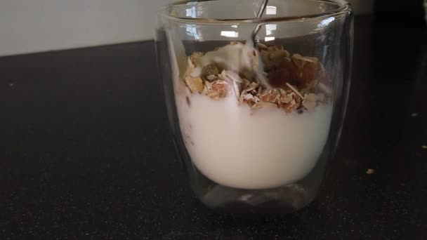 Mixing Yogurt Muesli Raisins Metal Spoon Class Cup Slowmotion — Vídeos de Stock