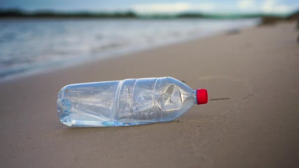 Stationary Close Plastic Bottle Sandy Beach Water Small Waves Background — Vídeo de Stock