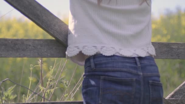Carefree Woman Leans Countryside Gate Looking Field Rapeseed — Stockvideo