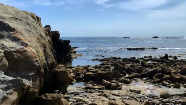 60P Rocks Beach Ocean Waves Lapping Sunny Day Blue Skies — Stock video