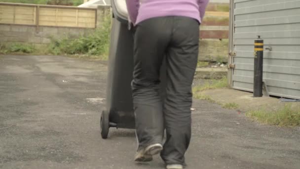 Woman Wheeling Out Grey Garbage Bin — Stockvideo