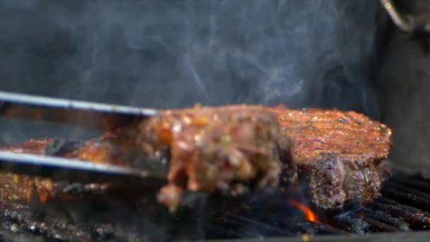 Pair Meat Tongs Turn Nearly Cooked Juicy Rib Eye Steak — 图库视频影像