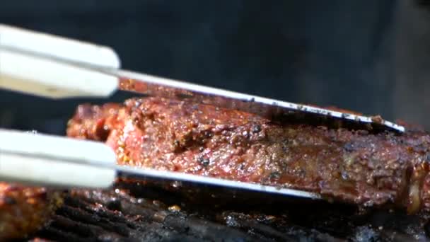 Pair Meat Tongs Turn Nearly Cooked Juicy Rib Eye Steak — Video Stock