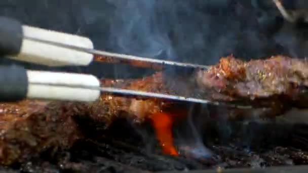 Pair Meat Tongs Turn Nearly Cooked Juicy Rib Eye Steak — Vídeos de Stock