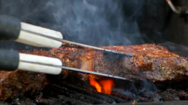 Pair Meat Tongs Turn Nearly Cooked Juicy Rib Eye Steak — Stock video