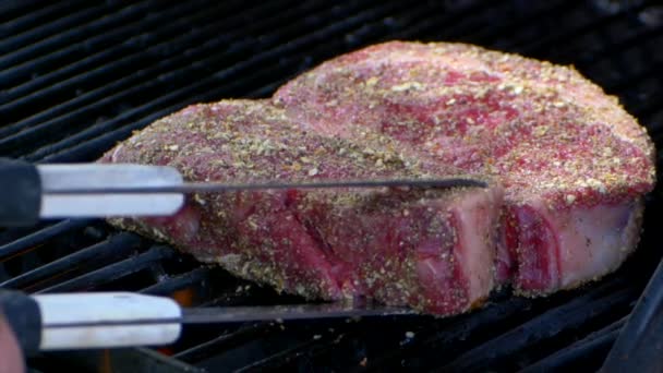Pair Meat Tongs Lift Nearly Cooked Juicy Rib Eye Steak — Stockvideo