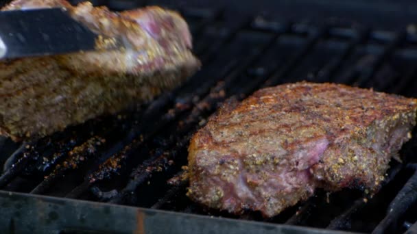 Pair Meat Tongs Turn Nearly Cooked Juicy Rib Eye Steak — стоковое видео