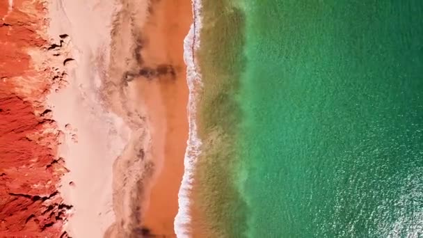 Scogliere Rosse Allineano Spiaggia Sabbiosa Mentre Piccole Onde Rompono Sulla — Video Stock