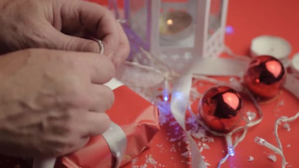 Tying Bow Christmas Gift Ribbons Red Paper Red Background Baubles — Stockvideo