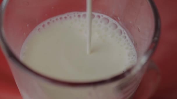 Pouring Milk Glass Red Background — Stockvideo