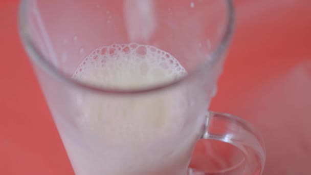 Pouring Milk Glass Red Background — Stockvideo