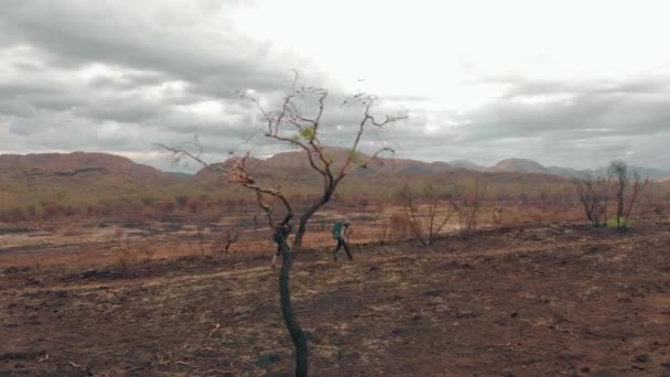 Aerial Tracking Hikers Burnt Landscape Distant Mountains — Stock Video