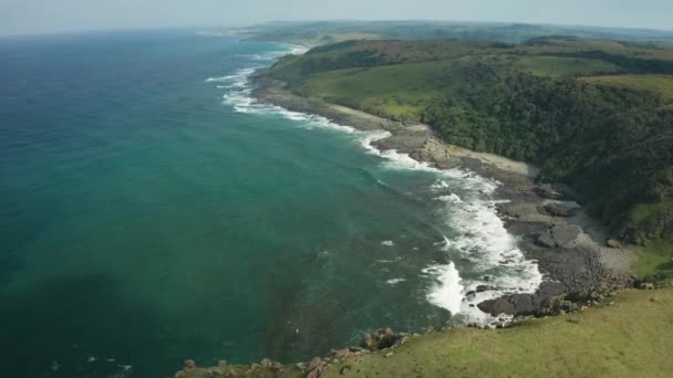 Aerial Pan Green Meadow Rocky Beach Texture Ocean Waves — Stok video