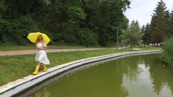 Woman White Dress Yellow Umbrella Walks Lake Reflection — Vídeos de Stock