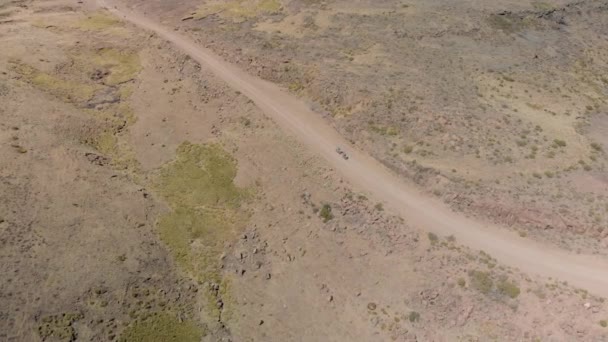 Aerial Shot Two Mountain Bikers Climbing Gravel Road Mountain Pass — Stockvideo