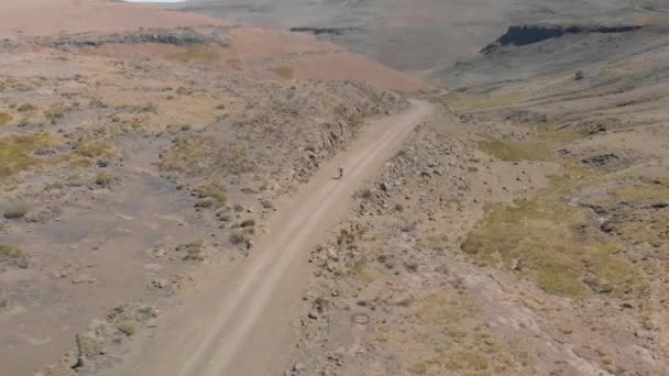 Aerial Shot Mountain Biker Climbing Pass Gravel Road — Stockvideo
