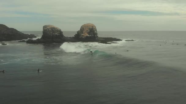 Aerial Surfer Riding Wave Next Giant Rocks Dark Cold Day — Stockvideo