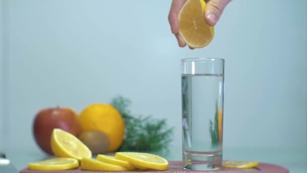 Slow Motion Squeezing Lemon Glass Clean Water Closeup Human Hand — Stockvideo