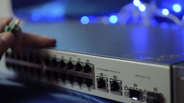 Network Engineer Securing Ethernet Cables Switch Blue Lights Background — Stok video