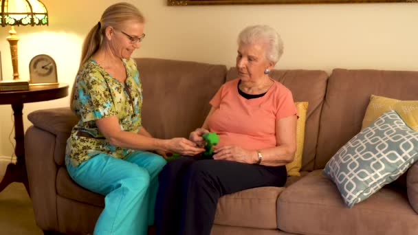 Physical Therapist Doing Home Healthcare Visit Elderly Woman Showing Her — Vídeos de Stock