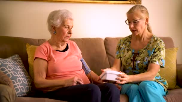 Home Healthcare Nurse Elderly Woman Taking Blood Pressure Monitor — Stock video