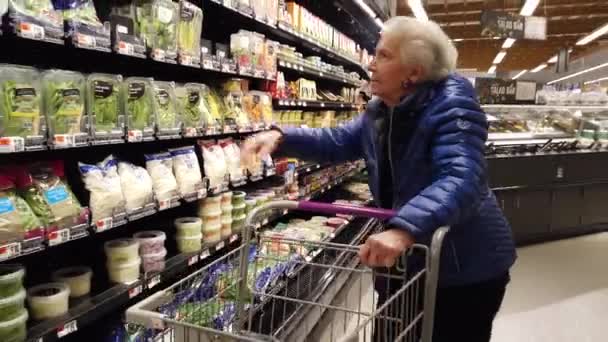 Elderly Woman Looking Bags Brussels Sprouts Grocery Store — Vídeo de stock