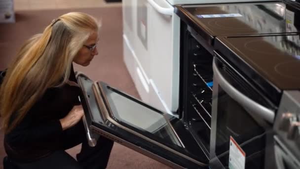 Pretty Mature Blonde Woman Shopping Stoves Kitchen Appliance Store — Video Stock