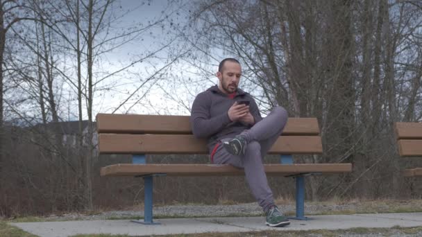 Young Bearded Man Short Hair Sitting Park Bench Cloudy Fall — Stockvideo