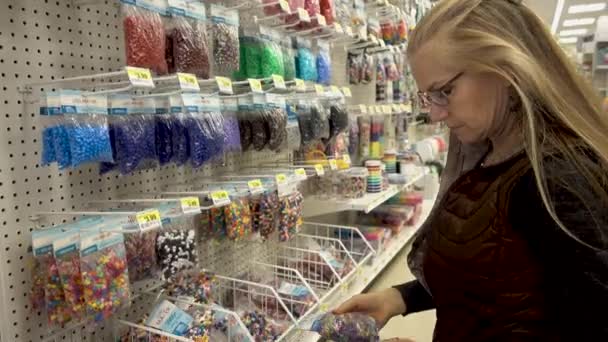 Closeup Pretty Mature Woman Looking Closely Multicolored Beads Craft Store — Stockvideo