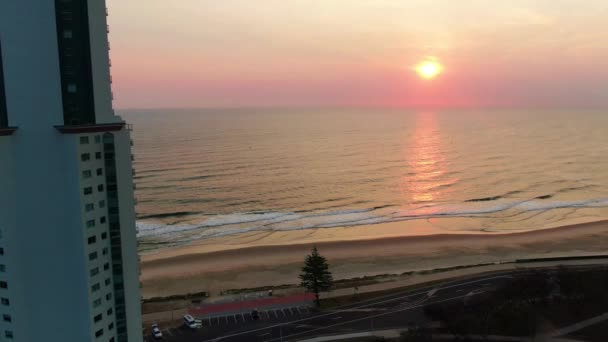 Pink Purple Sunrise Ocean Panning Right Apartments Foreground — Stockvideo