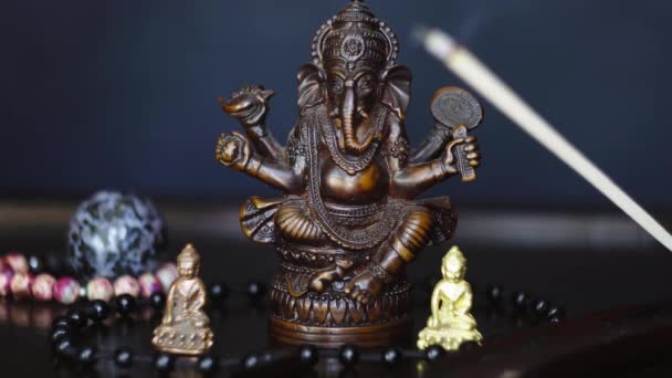 Zbliżenie Zdjęcia Postaci Ganeshy Małymi Figurkami Buddy Kulkami Modlitewnymi Kadzidełkiem — Wideo stockowe