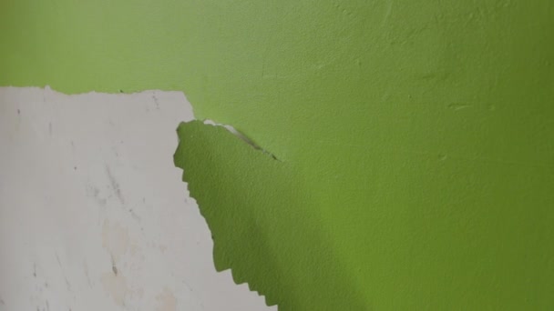 Steady Shot Man Scraping Green Paint Wall — Stok video