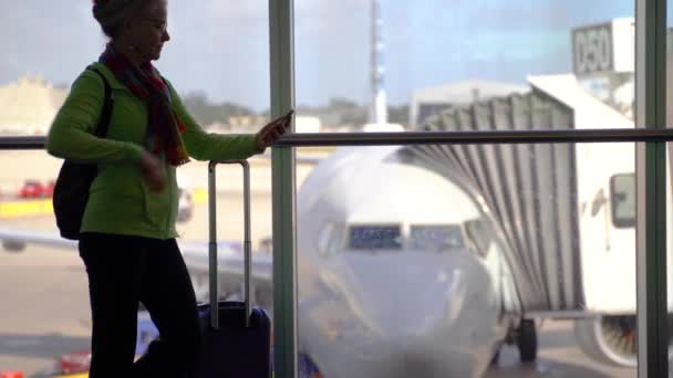 Силуэт Женщины Убирающей Свой Телефон Выкатывающей Кадра Размытым Самолетом Вдали — стоковое видео