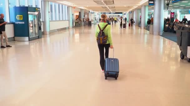 Camera Follows Woman Dragging Roll Suitcase Airport Night — Stok video