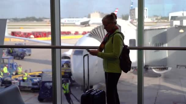 Indoors Silhouette Woman Traveler Luggage Checking Her Cellphone While Airplanes — Stockvideo