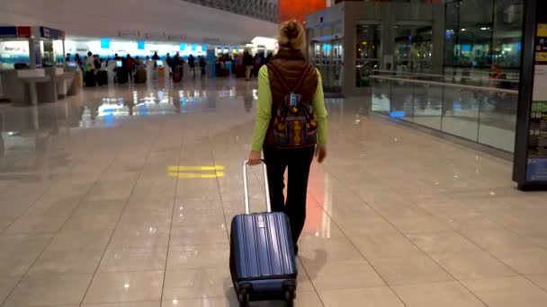 Camera Follows Woman Dragging Roll Suitcase Airport Night — Stockvideo