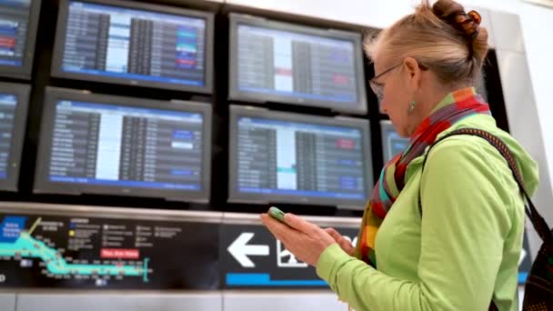 Closeup Woman Holding Smartphone Looking Her Flight Flight Information Display — Stok video