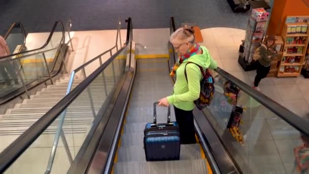 Mature Woman Rolling Carry Goes Airport Escalator — 图库视频影像