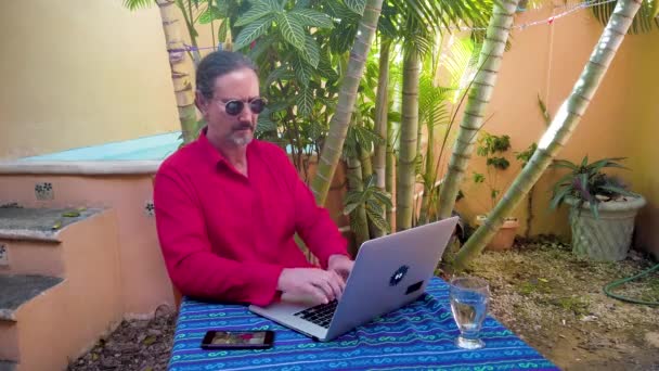 Mature Man Types Laptop Keyboard Table Garden Wearing Guayabera Shirt — Stockvideo