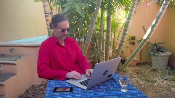 Mature Man Types Laptop Keyboard Table Garden Wearing Guayabera Shirt — Vídeos de Stock