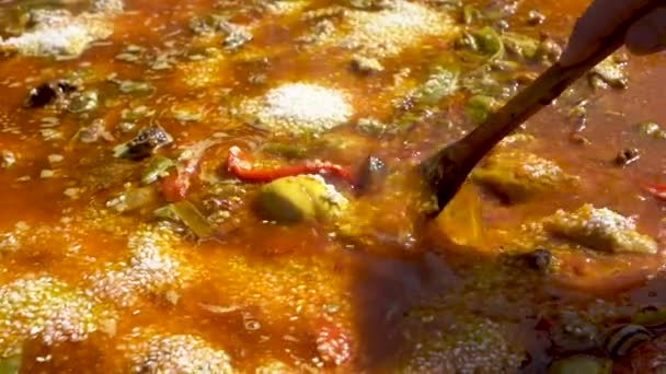 Close Shot Wooden Spoon Mixing Soupy Spanish Paella While Being — Vídeo de Stock