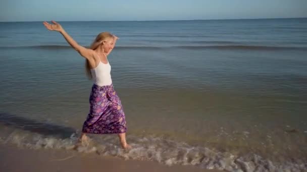 Arms Outstretched Slow Motion Clip Mature Woman Splashing Water Beach — Stock Video