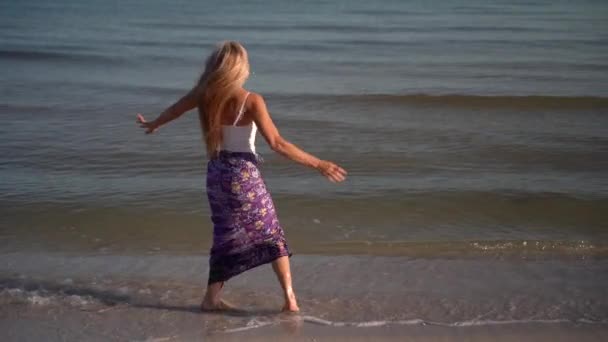 Slow Motion Mature Woman Sarong Walking Beach Splashing Water Sunrise — стоковое видео